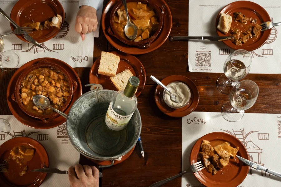 Vista cenital de una mesa compartida con platos tradicionales mallorquines