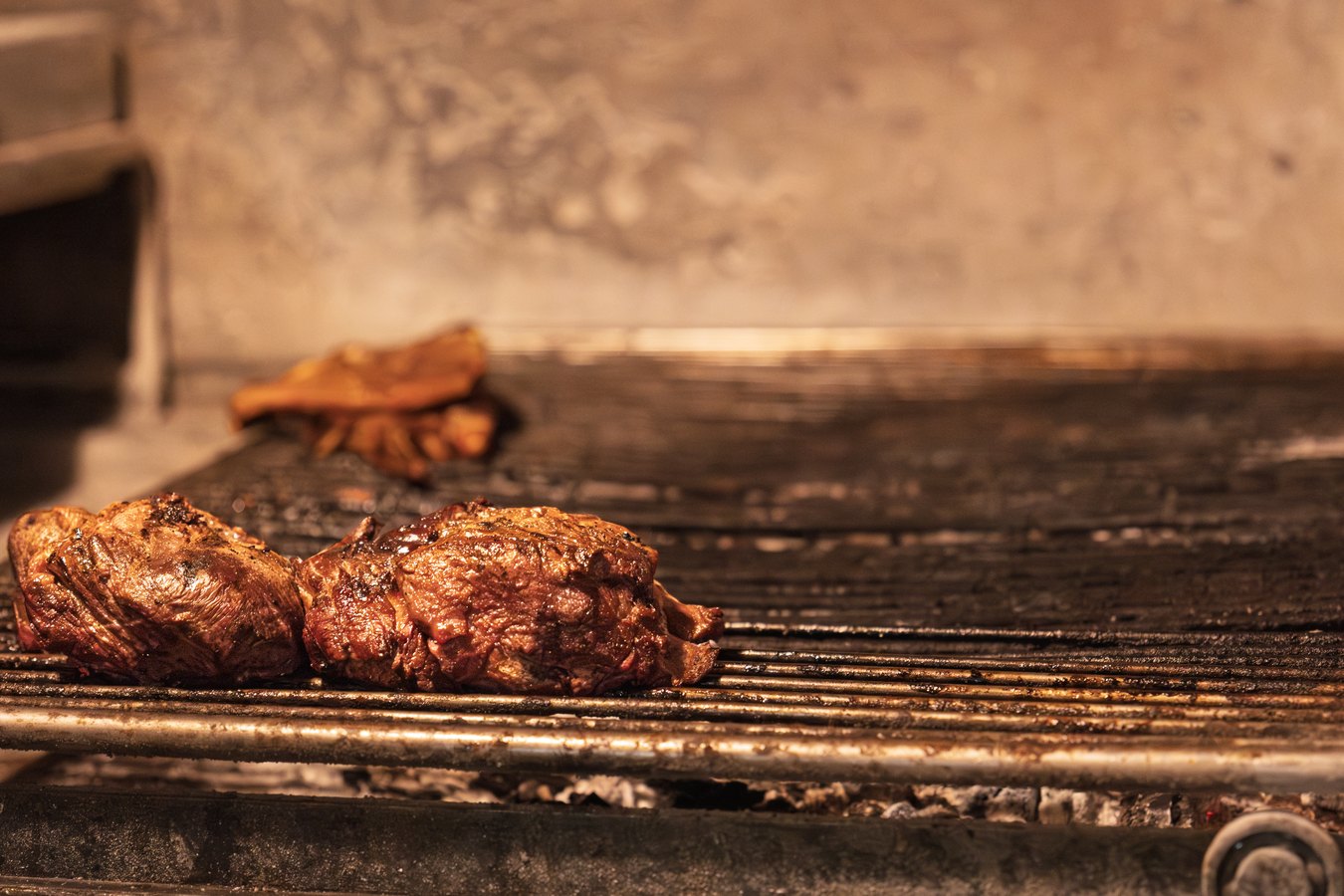 Carnes asándose lentamente sobre el caliu