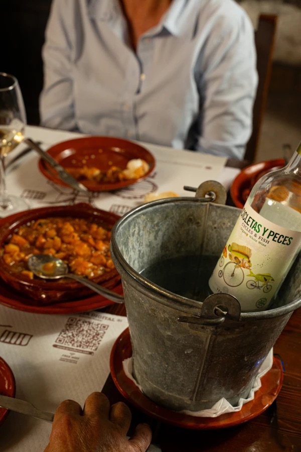 Mesa con comensales y vino en Es Celler de Petra