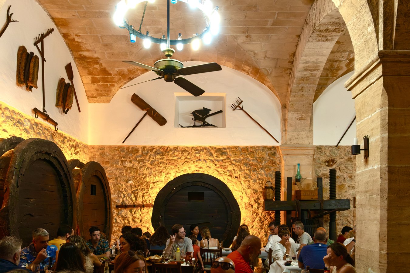 Sala abovedada del celler con las botas de vino y las mesas ocupadas