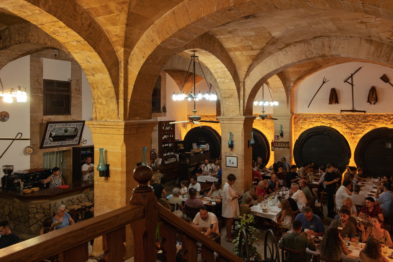 Vista del comedor desde la escalera, con la barra y las botas al fondo
