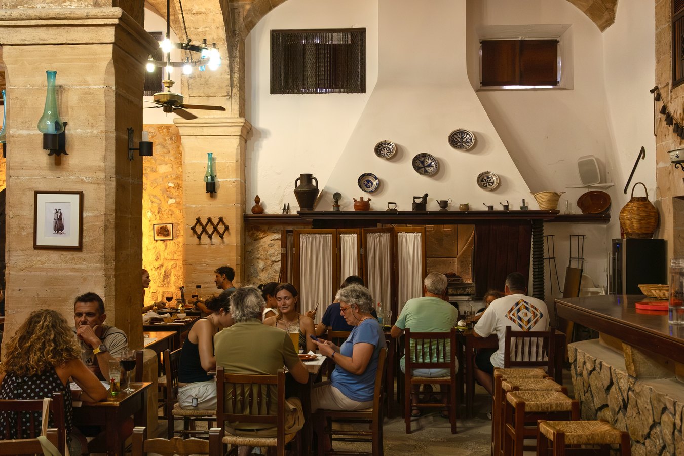 Comedor junto a la chimenea, con la cerámica mallorquina en la pared
