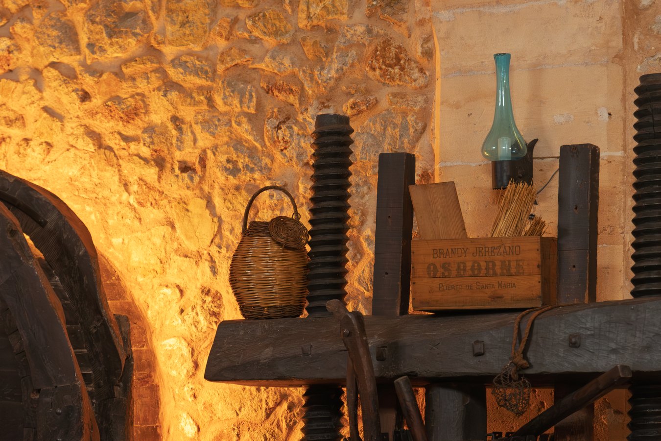Antigua prensa de vino y una de las botas del celler