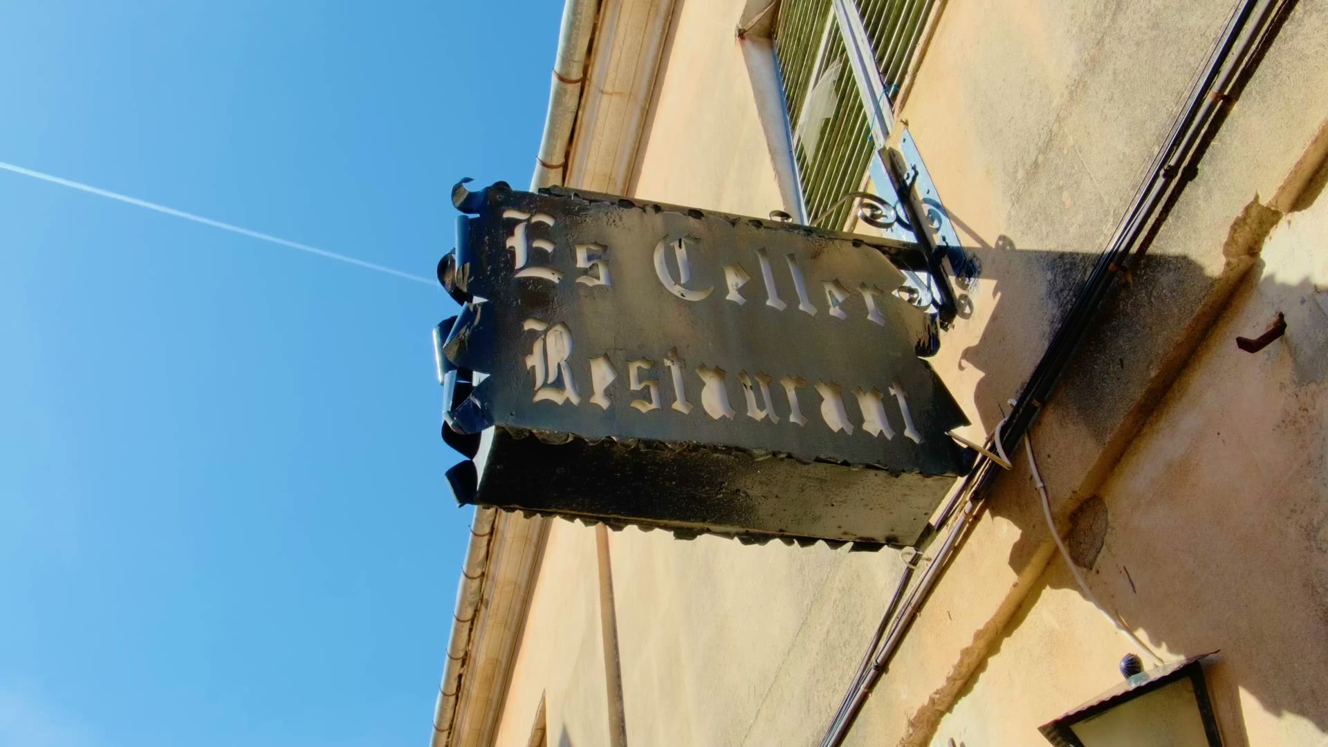 Rótulo de hierro forjado del restaurante Es Celler de Petra en la fachada