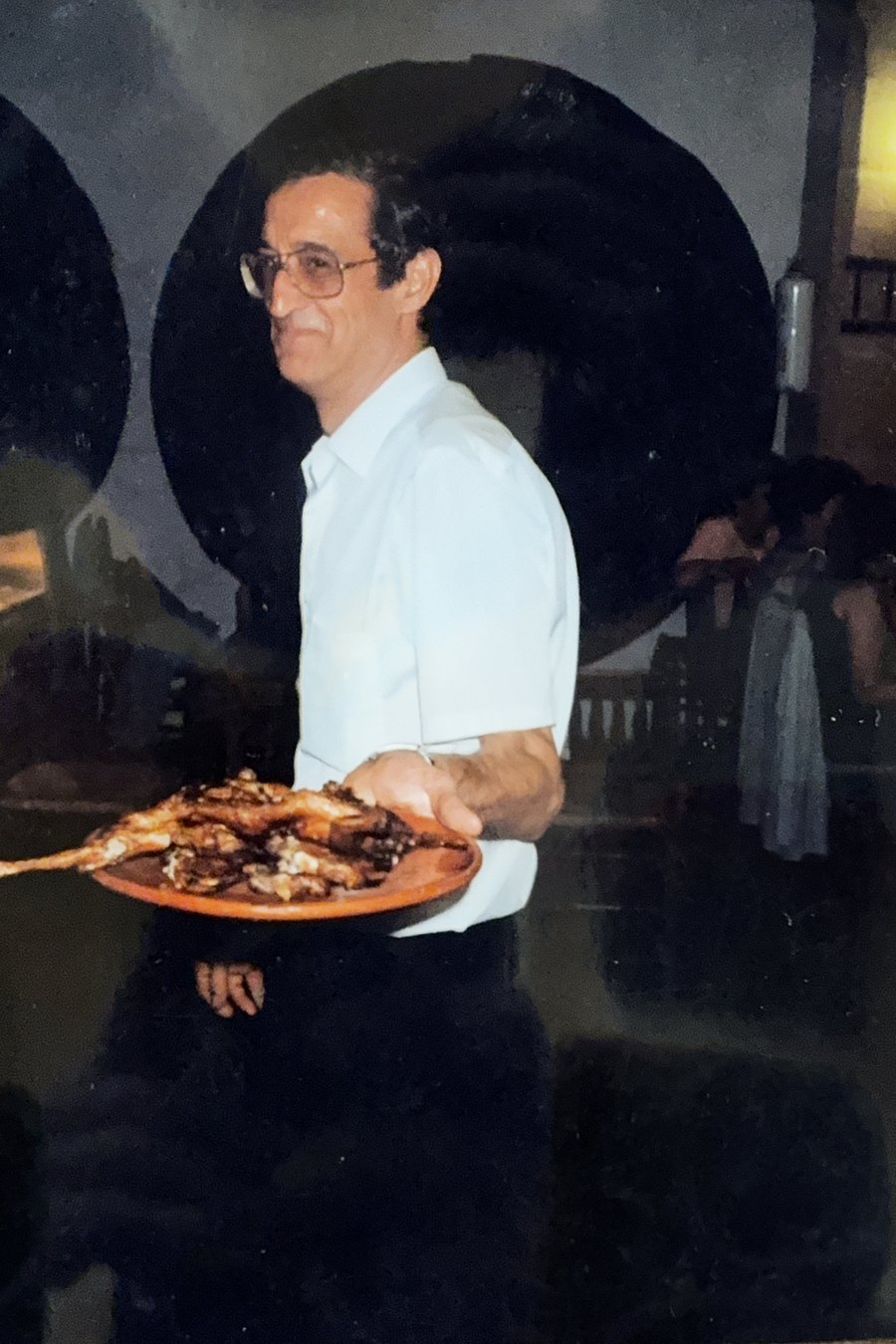 Fotografía antigua: un camarero con una bandeja de asado